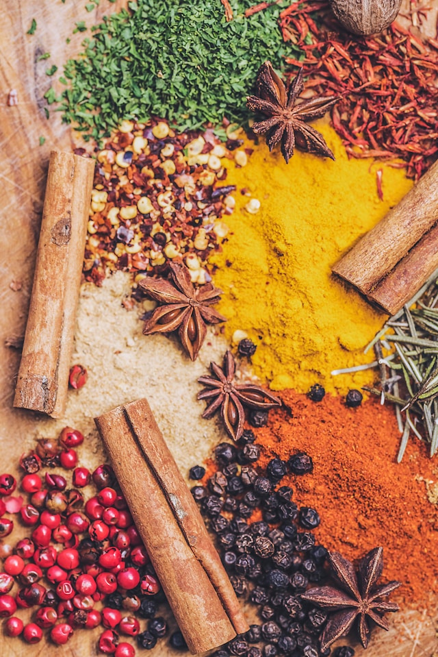 Various colorful spices in bowls on a dark background